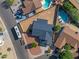 Aerial view of the home showing the roof, backyard, and neighboring properties, including a pool at 8620 W Denton Ln, Glendale, AZ 85305