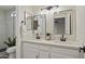 Well-lit bathroom with double sinks, modern fixtures, and a sleek, glass-enclosed shower at 8620 W Denton Ln, Glendale, AZ 85305