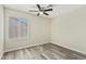 Cozy bedroom with a ceiling fan, bright window, and wood-look flooring at 8620 W Denton Ln, Glendale, AZ 85305