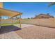 Spacious backyard featuring a covered patio, gravel area, and block wall for privacy at 8835 W John Cabot Rd, Peoria, AZ 85382