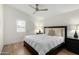 Cozy bedroom features a ceiling fan, wood-look floors, and natural light from the window at 8835 W John Cabot Rd, Peoria, AZ 85382