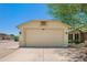 View of the two car garage with a neutral color scheme and desert landscaping at 8835 W John Cabot Rd, Peoria, AZ 85382