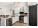 Well-appointed kitchen features stainless steel appliances, white cabinets, and sleek marble countertops at 8835 W John Cabot Rd, Peoria, AZ 85382