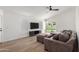 A spacious living room featuring a ceiling fan, hardwood floors, and modern furniture and decor at 8835 W John Cabot Rd, Peoria, AZ 85382