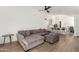 Cozy open-plan living space features hardwood floors, a sectional sofa, and an open view of the kitchen at 8835 W John Cabot Rd, Peoria, AZ 85382