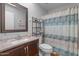 Cozy bathroom with single sink vanity, decorative framed mirror, and shelf storage for towels at 10895 W Clair Dr, Sun City, AZ 85351