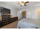 Spacious bedroom features carpet floors, a ceiling fan, and a wall-mounted TV at 10895 W Clair Dr, Sun City, AZ 85351