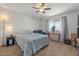 Cozy bedroom featuring a ceiling fan, a large bed, and a window at 10895 W Clair Dr, Sun City, AZ 85351