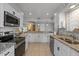 Modern kitchen with stainless steel appliances, granite countertops, and ample storage at 10895 W Clair Dr, Sun City, AZ 85351
