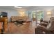 Comfortable living room featuring an oversized couch, brick walls, and wood flooring at 10895 W Clair Dr, Sun City, AZ 85351