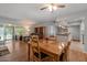 Cozy living room featuring wood floors, a dining table, and access to the backyard at 10895 W Clair Dr, Sun City, AZ 85351