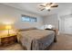Cozy main bedroom featuring a large bed, a stained-glass window, and a ceiling fan at 10895 W Clair Dr, Sun City, AZ 85351