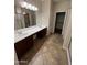 Bathroom with dual sinks, a large mirror, and a glass-enclosed shower at 11249 N 161St Ave, Surprise, AZ 85379