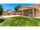 Private backyard showcasing a covered patio, spacious lawn, and block fence at 11724 N 148Th Ave, Surprise, AZ 85379
