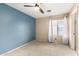 Bright bedroom with neutral carpet, a ceiling fan, and large window at 11724 N 148Th Ave, Surprise, AZ 85379