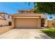 A two-car garage and driveway of a well-maintained, two-story home under a clear blue sky at 11724 N 148Th Ave, Surprise, AZ 85379