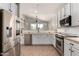 Well-lit kitchen features stainless steel appliances, tile countertops, and white cabinets at 11724 N 148Th Ave, Surprise, AZ 85379