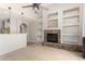 Bright living room with stone fireplace, built-in shelving, and adjacent breakfast bar at 11724 N 148Th Ave, Surprise, AZ 85379
