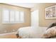 Bright bedroom featuring plantation shutters, a closet, wood floors, and neutral paint at 12212 N 66Th St, Scottsdale, AZ 85254