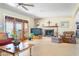 Bright living room featuring tiled flooring, a stone fireplace, comfortable seating, and backyard views at 12212 N 66Th St, Scottsdale, AZ 85254