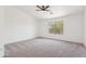 Neutral bedroom showcasing plush carpeting, large window, and ceiling fan at 1239 W Descanso Canyon Dr, Casa Grande, AZ 85122