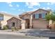 Charming two-story home with a three car garage, tan exterior, and well-manicured landscaping at 1239 W Descanso Canyon Dr, Casa Grande, AZ 85122
