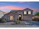 Stunning two-story home showcasing meticulous desert landscaping, arched entry and custom shuttered windows at 1239 W Descanso Canyon Dr, Casa Grande, AZ 85122