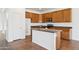 Open kitchen design with tiled floors, featuring a central island, wooden cabinets, and modern appliances at 1239 W Descanso Canyon Dr, Casa Grande, AZ 85122