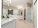 Bright bathroom featuring double sinks, quartz countertops, a large mirror, and walk-in shower at 13041 S 45Th Pl, Phoenix, AZ 85044