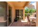 Relaxing covered patio with seating, lush greenery, and a sliding glass door entrance at 13041 S 45Th Pl, Phoenix, AZ 85044
