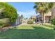 Well-maintained backyard featuring a lush lawn, pool, shed, beautiful landscaping, and outdoor lounging area at 13824 W Gelding Dr, Surprise, AZ 85379