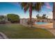 Backyard with pool, lawn, shed, and desert landscaping at 13824 W Gelding Dr, Surprise, AZ 85379