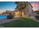Green backyard featuring a swimming pool, patio, and well-maintained landscaping at 13824 W Gelding Dr, Surprise, AZ 85379
