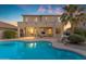 Beautiful backyard with a swimming pool, covered patio, and meticulously maintained landscaping at 13824 W Gelding Dr, Surprise, AZ 85379