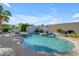 The backyard features a custom pool with a charming waterfall feature, a basketball hoop, and lush landscaping at 13824 W Gelding Dr, Surprise, AZ 85379