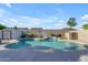 The backyard features a custom pool with a charming waterfall feature, a basketball hoop, and lush landscaping at 13824 W Gelding Dr, Surprise, AZ 85379