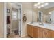 Well-lit bathroom featuring a vanity, a mirror, and a tiled floor at 13824 W Gelding Dr, Surprise, AZ 85379