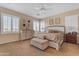Inviting primary bedroom with neutral tones, carpet, plantation shutters, and a ceiling fan at 13824 W Gelding Dr, Surprise, AZ 85379