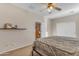 A well-lit bedroom with carpeted floors, shelf, and a double door closet at 13824 W Gelding Dr, Surprise, AZ 85379