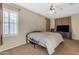 Cozy bedroom featuring a ceiling fan, carpet floors, and shuttered window at 13824 W Gelding Dr, Surprise, AZ 85379