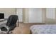 Bedroom with beige carpet, an office chair, and an attached closet at 13824 W Gelding Dr, Surprise, AZ 85379