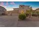 Two-story home with a well-maintained yard, three-car garage, and desert landscaping at 13824 W Gelding Dr, Surprise, AZ 85379