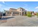 Expansive three car garage attached to a two story home with stone accents and desert landscaping at 13824 W Gelding Dr, Surprise, AZ 85379