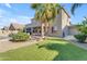 Charming two-story home featuring a covered patio, beautiful landscaping, lush lawn, and a sparkling pool at 13824 W Gelding Dr, Surprise, AZ 85379