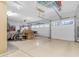 Clean, organized garage space featuring ample lighting, storage and door to the exterior at 13824 W Gelding Dr, Surprise, AZ 85379