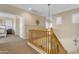 Bright upstairs hallway with tan carpet and wooden railing at 13824 W Gelding Dr, Surprise, AZ 85379