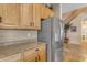 Well-appointed kitchen with stainless steel refrigerator, wooden cabinets and granite countertop at 13824 W Gelding Dr, Surprise, AZ 85379