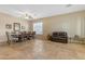 Spacious living room featuring neutral walls, tile flooring, plantation shutters, and a ceiling fan at 13824 W Gelding Dr, Surprise, AZ 85379