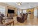 Expansive living room featuring hardwood floors, a kitchen, and a leather reclining sofa at 13824 W Gelding Dr, Surprise, AZ 85379