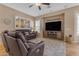 Cozy living room features leather sofas, a ceiling fan, and a built-in entertainment center at 13824 W Gelding Dr, Surprise, AZ 85379